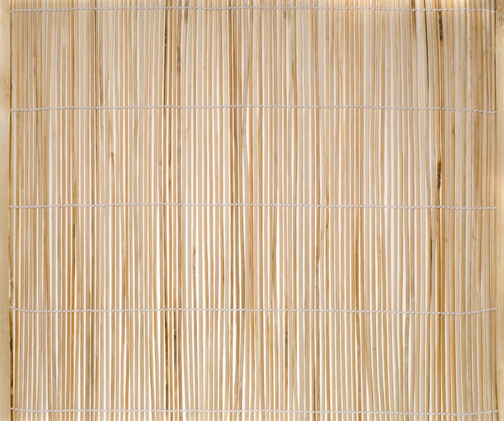 Bamboo, a natural material, weaved together into a mat.
